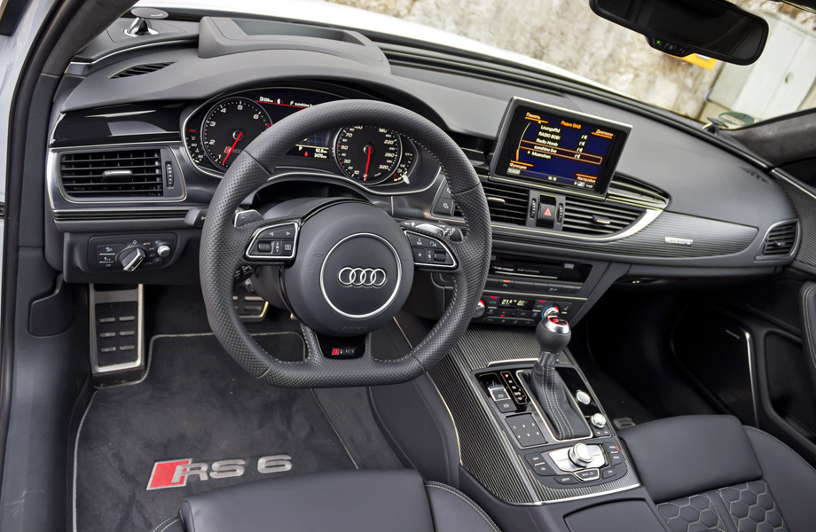             Знакомый интерьер украшен спортивной атрибутикой (подпиленный по хорде руль, металлические накладки на педалях) и надписями RS6 повсюду. Глаз режет лишь одна деталь — грубая нашлёпка за козырьком приборов, в которой спрятался проектор информации на лобовое стекло. Удобную посадку сможет подобрать человек любой комплекции — диапазоны регулировок руля и кресел дарят свободу в выборе.
