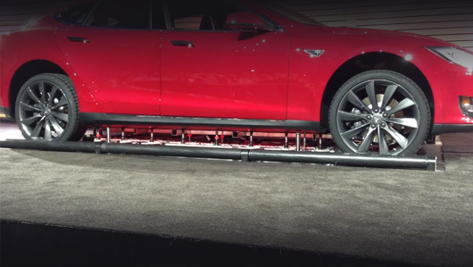 Tesla model s. Для выполнения процедуры автомобиль чуть-чуть приподнимается, чтобы зафиксировать его точно над «лифтом» для батареи.