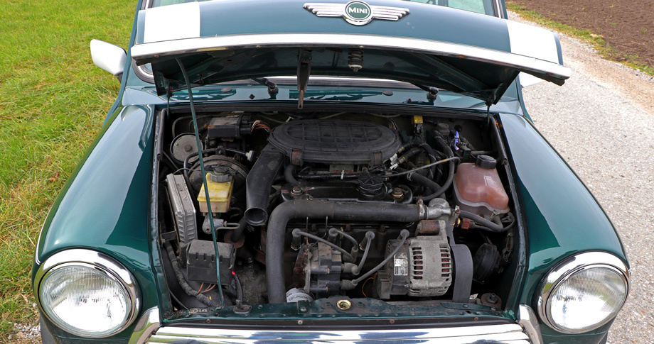             Все 40 лет с лишним на классические Mini ставился роверовский мотор серии А, переживший уйму модификаций, ― здесь, например, радиатор переехал вперёд, под генератор. Главный тормозной цилиндр и вакуумный усилитель стоят справа даже на леворульных машинах.

